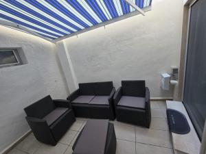 a room with two chairs and a couch and a ceiling at B&B Fiore di Maggio in Mola di Bari