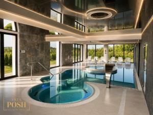 a large swimming pool with a table and chairs at Villa Posh All Suites Hotel & SPA in Międzywodzie