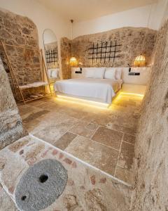 a bedroom with a bed and a stone wall at Adyton Guest House in Didim +31 photos