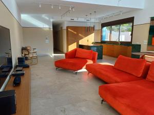 a living room with two orange couches and a kitchen at Luxury Villa Galaxy Beach 12min walk 15m pool in Calpe
