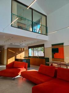 a living room with two red couches and a balcony at Luxury Villa Galaxy Beach 12min walk 15m pool in Calpe +35 photos