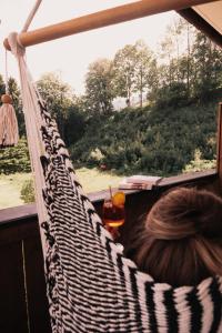 a woman sitting in a hammock looking out a window at Hotel Martini Kaprun including free parking and Zell am See-Kaprun summer card in Kaprun +41 photos