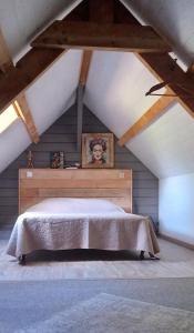 a bedroom with a large bed in a attic at La cabane de Jane in Saint-Bonnet-lʼEnfantier