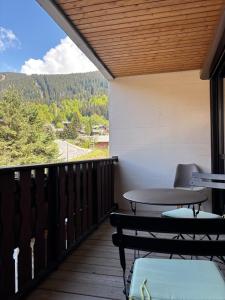 a patio with a table and chairs on a balcony at Whitebearlodge in Arâches-la-Frasse