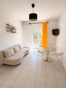 a living room with a couch and a glass table at Apartmani Leona in Metajna