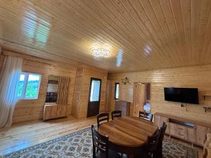 a wooden dining room with a wooden table and chairs at Горный коттедж in Kobuleti