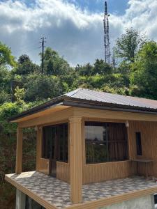 a wooden cabin with a large window on top at Горный коттедж in Kobuleti