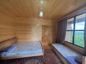 a room with two beds in a wooden cabin at Горный коттедж in Kobuleti