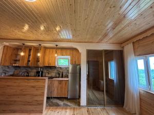 a kitchen with wooden cabinets and a stainless steel refrigerator at Горный коттедж in Kobuleti +5 photos