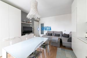 a white living room with a couch and a table at Residence Maricel in Lido di Jesolo