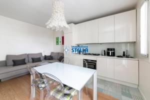 a kitchen and living room with a white table and chairs at Residence Maricel in Lido di Jesolo