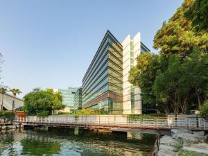 a bridge over a river in front of a building at The Creekside Hotel, Dubai - an Accor Hotel in Dubai