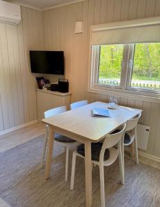 a dining room with a table and chairs and a tv at Brissundsbyn in Visby