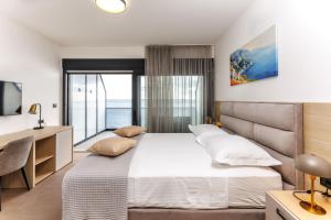 a bedroom with a large bed and a television at Stella Maris Beach in Podstrana