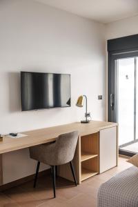 a desk with a chair and a television on a wall at Stella Maris Beach in Podstrana