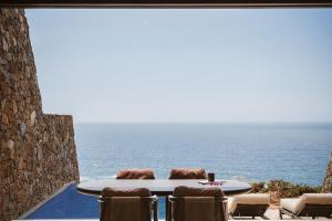 a table and chairs with a view of the ocean at The Revery, Elafonisi - Member of Leading Hotels of the World in Livadia +61 photos