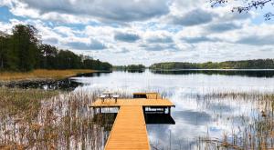 a dock on a lake with chairs on it at Rudziaszka in Otole +35 photos