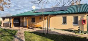 a large yellow house with a green roof at Pájer Plázs & Resort in Gyomaendrőd