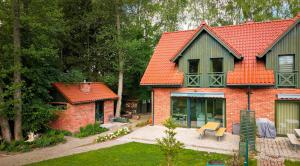 a brick house with an orange roof and a bench at Rudziaszka in Otole