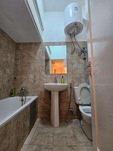 a bathroom with a sink and a tub and a toilet at Luxury Comfort House in Maputo +22 photos