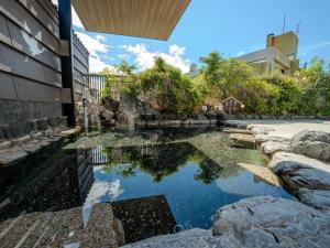a pond in the middle of a yard at Hotel Luna Park in Matsuyama