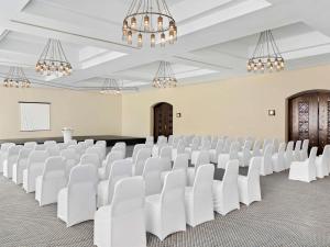 a large room with white chairs and chandeliers at Swissotel Resort El Quseir in Quseir +147 photos