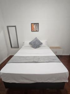 a large white bed in a white room at Luxury Comfort House in Maputo