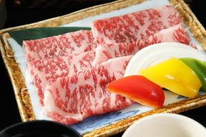 a tray of meat and cheese and fruit on a plate at Hotel Luna Park in Matsuyama