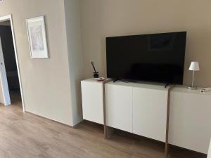a flat screen tv sitting on top of a white cabinet at Maiullari Holiday House in Policoro