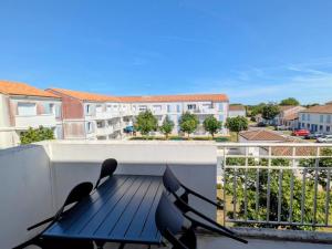 a balcony with a blue table and chairs on it at Le cocon de Marennes in Marennes