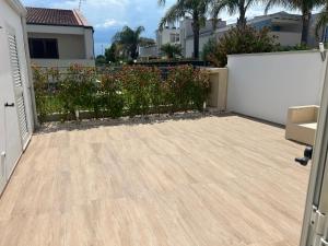 a backyard with a wooden floor and a fence at Maiullari Holiday House in Policoro