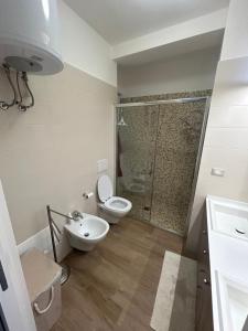 a bathroom with a toilet and a sink and a shower at Maiullari Holiday House in Policoro +10 photos