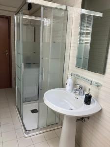 a bathroom with a sink and a glass shower at Fondobanchetto in Ferrara +9 photos
