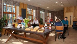 a group of people sitting around a table in a room at Cote Ghyll Mill Holiday Apartments in Osmotherley