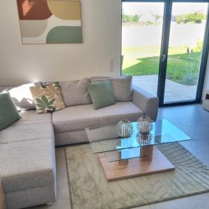 a living room with a couch and a glass table at Moderne Ferienwohnung,im fränkischen Seenland , 25 min Messe Nbg in Roth