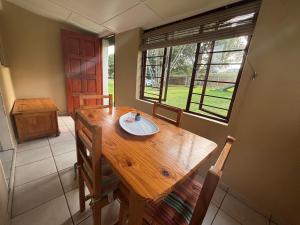 a dining room with a wooden table and a window at Siesta Island #5 in Amanzimtoti