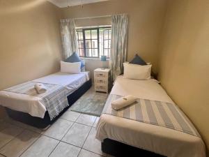 a bedroom with two beds and a window at Siesta Island #5 in Amanzimtoti