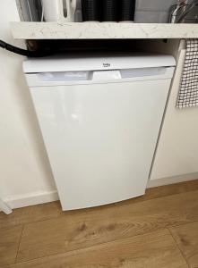 a white dishwasher under a counter in a kitchen at Hawtհorn Guestհouse in Cambridge