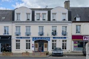 a large white building with a car parked in front at Hôtel Restaurant Le Plat d'Etain in Brou