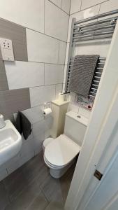 a white bathroom with a toilet and a sink at Hawtհorn Guestհouse in Cambridge