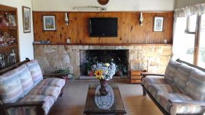 a living room with a couch and a fireplace at Hotel Mariska Dos Estrellas Superior in Villa Gesell