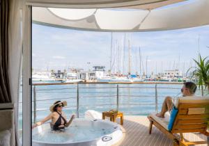 a man and a woman sitting in a hot tub on a balcony at Luxury Floating Apartment - Amor in Split