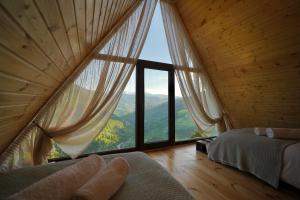 a bedroom with a large window with a view at Shavsheti view Cottage in Didachara +64 photos