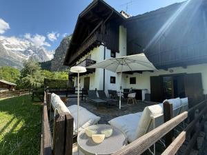 a patio with an umbrella and a table and chairs at Courmayeur 2BR Terrace Mont Blanc View & Parking in Courmayeur