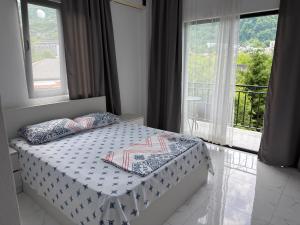 a bedroom with a bed and a window with a balcony at Hotel Palm Gonio in Kvariati