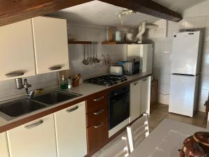 a kitchen with white cabinets and a sink and a stove at Fondobanchetto in Ferrara