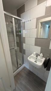 a bathroom with a sink and a shower at Hawtհorn Guestհouse in Cambridge