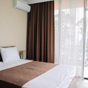 a bedroom with a bed and a large window at Hotel Scorpio gonio in Gonio