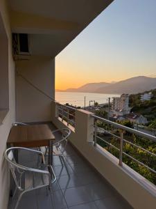 a balcony with a table and chairs and the ocean at Aria Apartments in Borsh