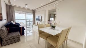 a dining room with a white table and chairs at SHB - Refinement, Ocean View, Sauna and Pool! in Santos